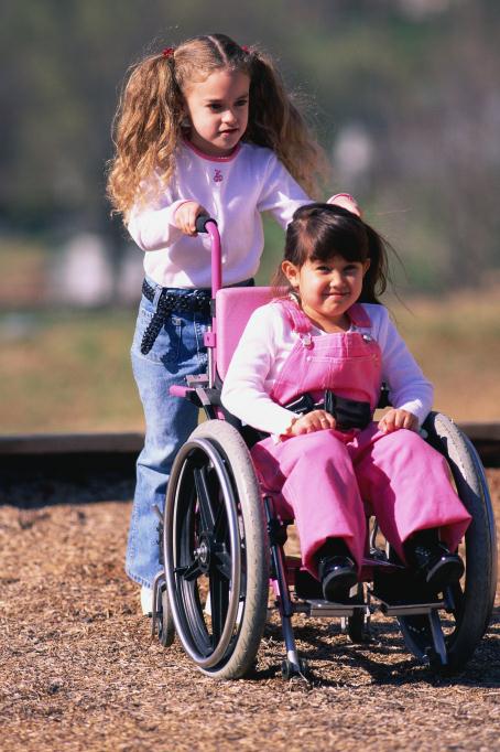 girl pushing friend in wheelchair